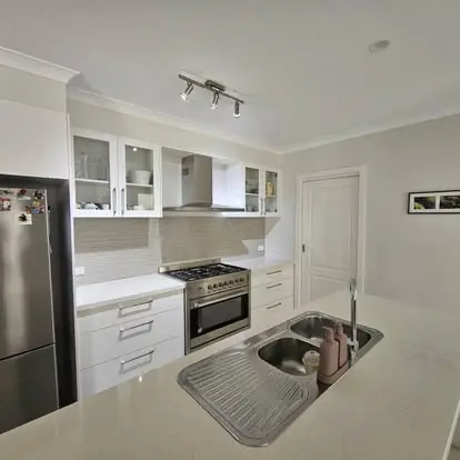 Bright white kitchen with tiled splashback and dark timber-look flooring